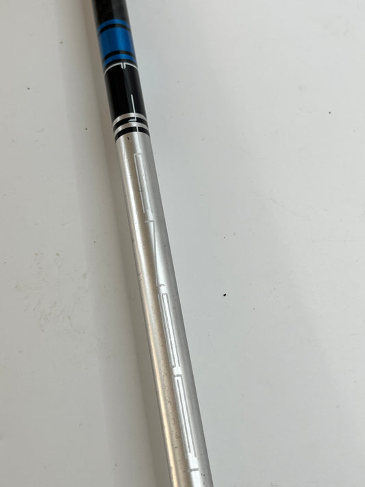 Close-up of a golf club shaft with a silver and black design on a white background