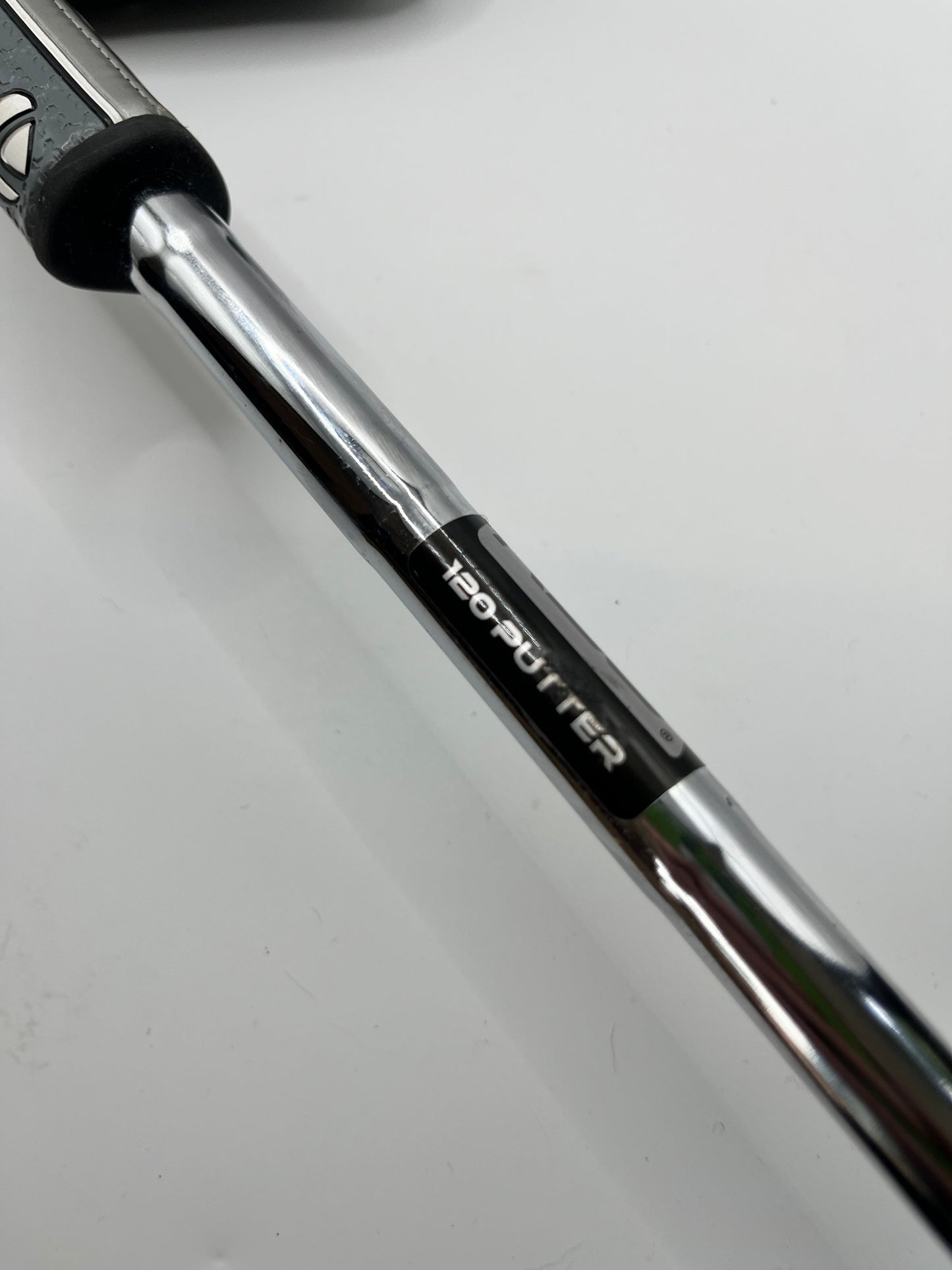 Close-up of a golf club shaft with '120-putter' branding on a white background