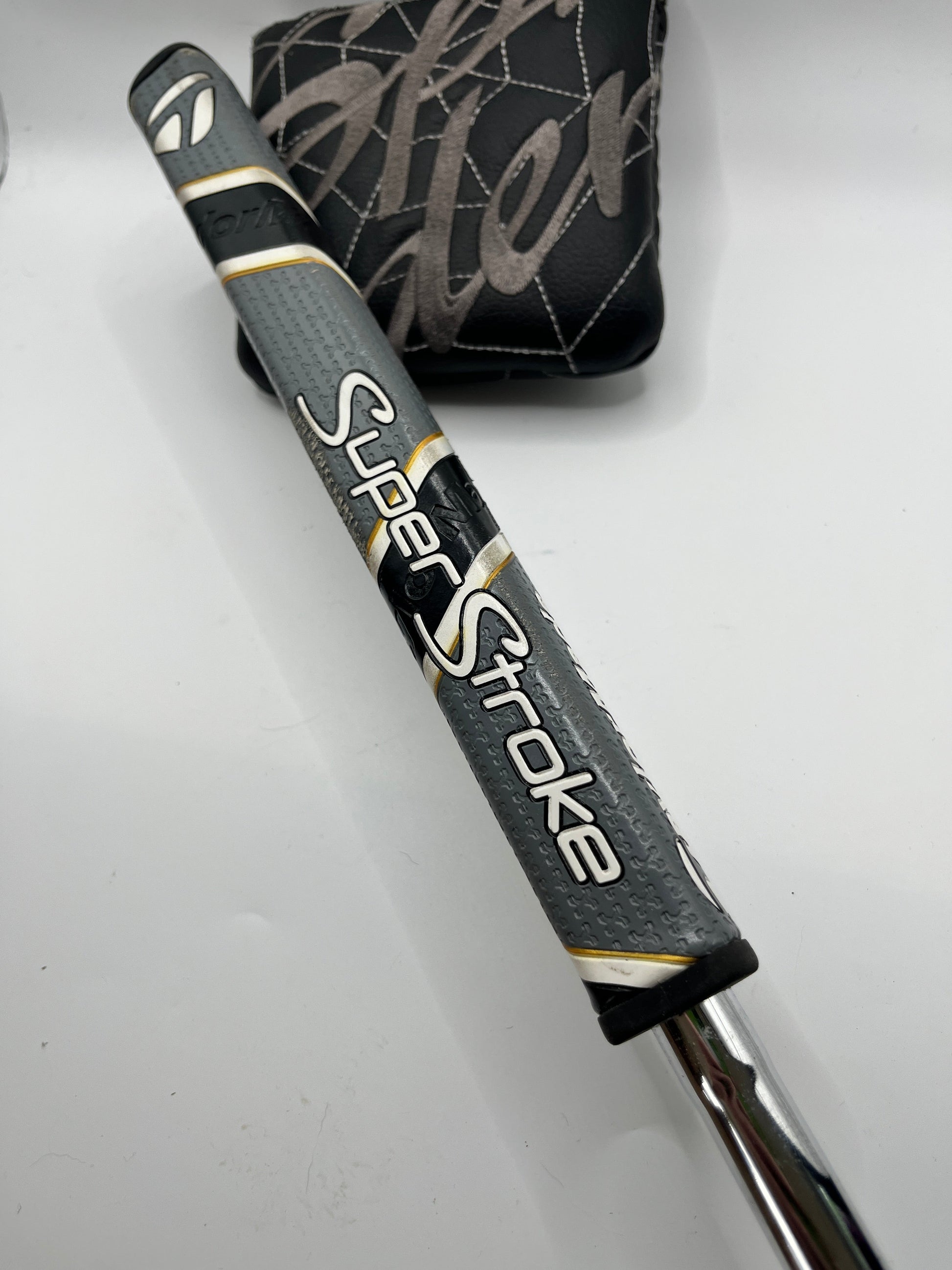 Golf club with SuperStroke putter grip on a white background