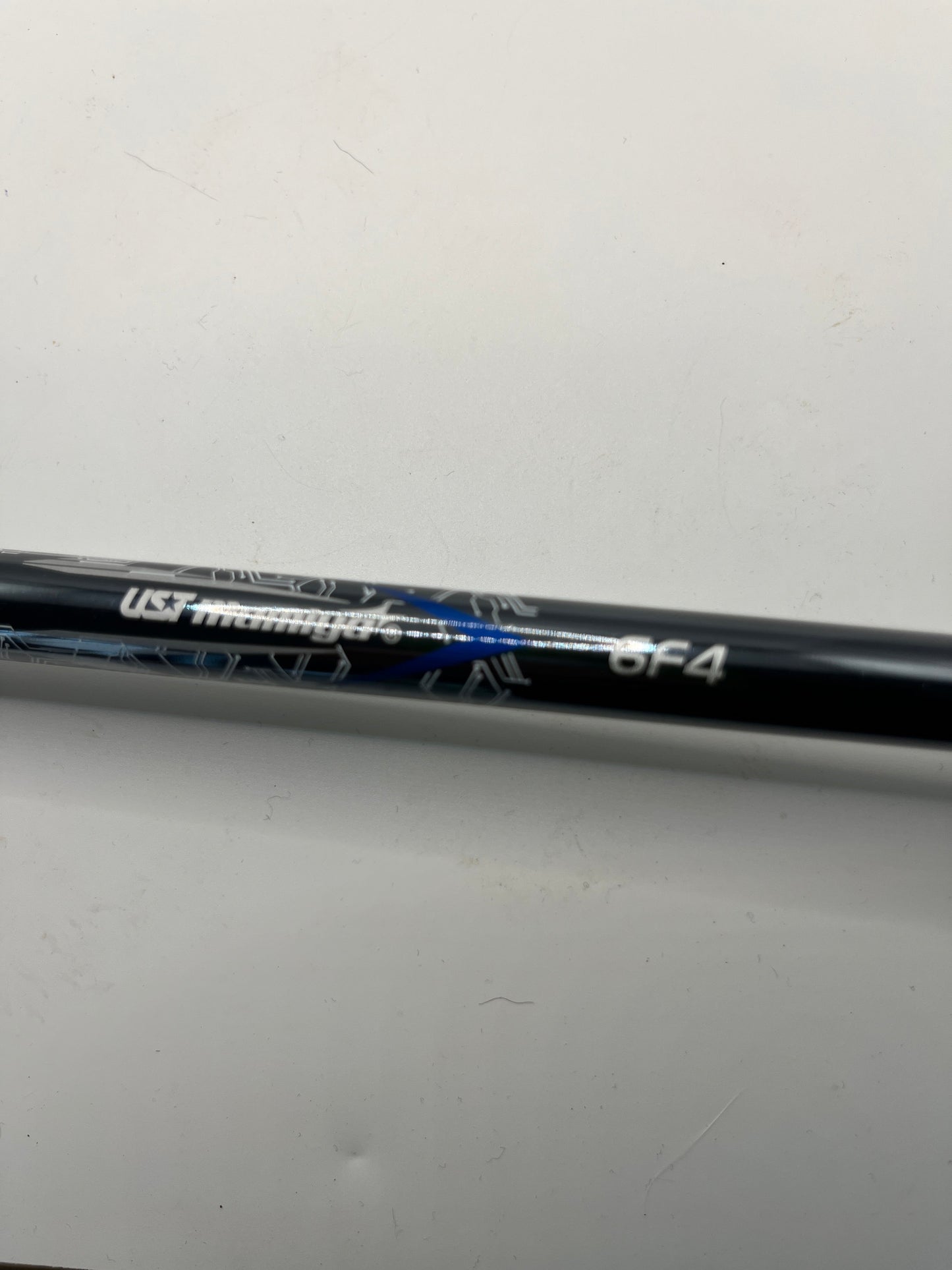 Golf club shaft with branding on a light gray background